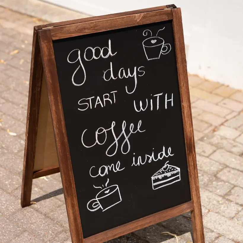 Het krijtbord voor de deur: good days start with coffee, come inside