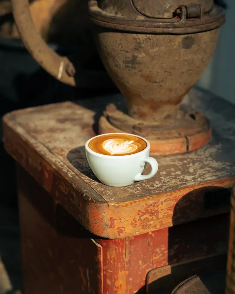 Een kopje koffie op de oude koffiebrander in de branderij